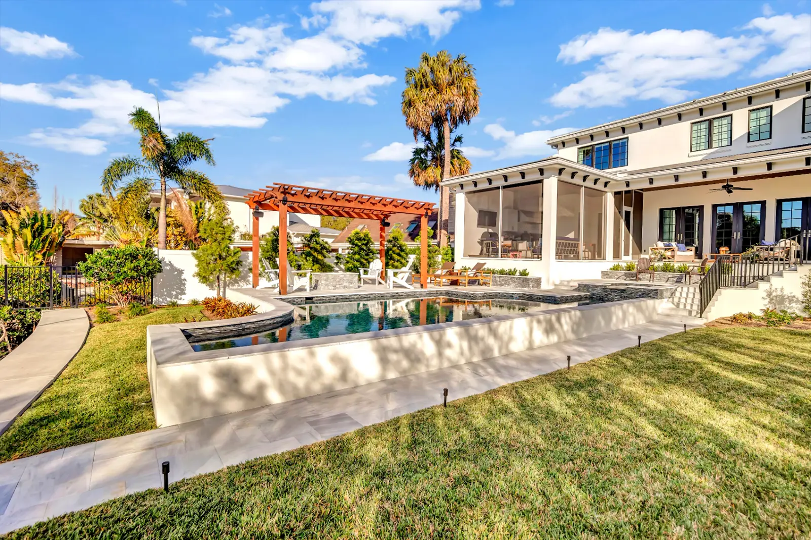 Tropical freeform pool with rock waterfall in St. Petersburg backyard